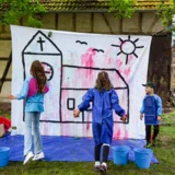 Im Pfarrgarten konnten die Kinder beim Schwammwerfen eine kunterbunte Kirche gestalten.  © Julia Otto